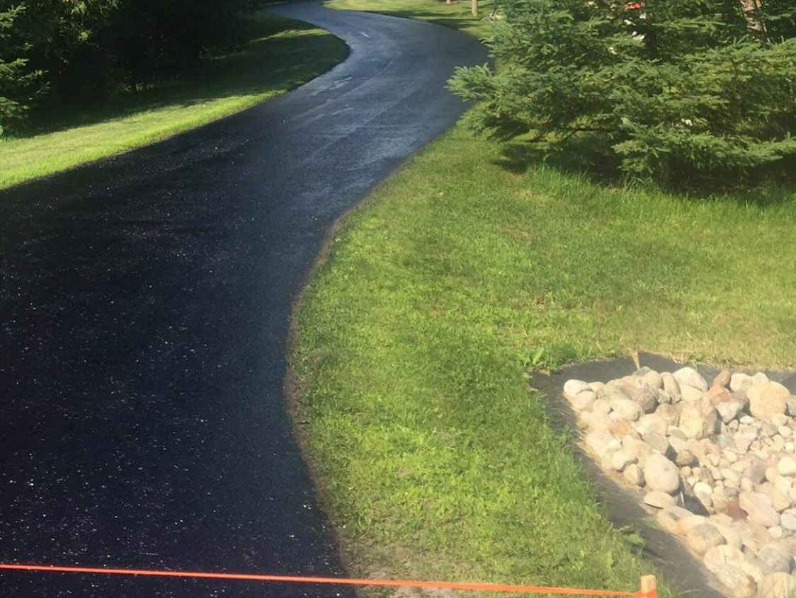 long rural driveway with freshly sealed asphalt